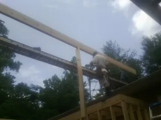 Carpenter setting a ridge beam over a new addition frame — Ice Dam Removal by Roofing Brothers in Browder