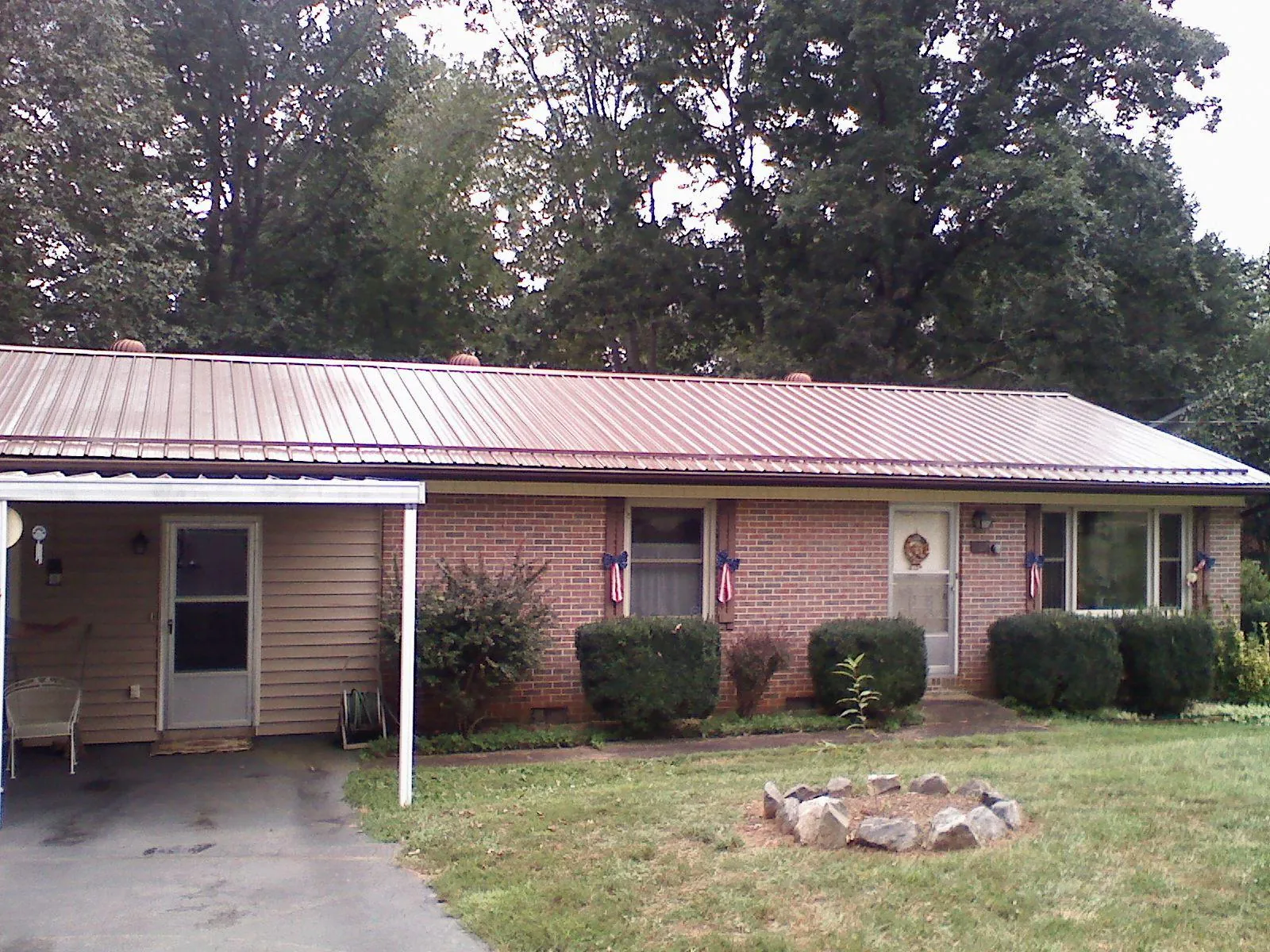Bronze metal roof and carport on a brick ranch home — Roof Repair work by our crew in Browder